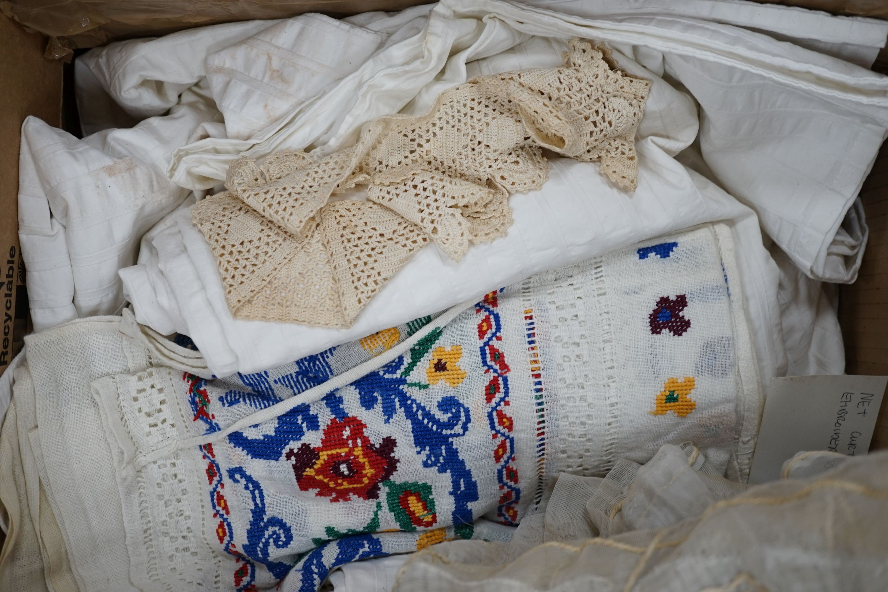 A box of mixed linen and 1950's hand embroidered cream curtain